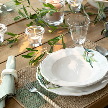 Mediterran gedeckter Esstisch mit Keramikgeschirr und Leinen im französisch inspirierten Ambiente